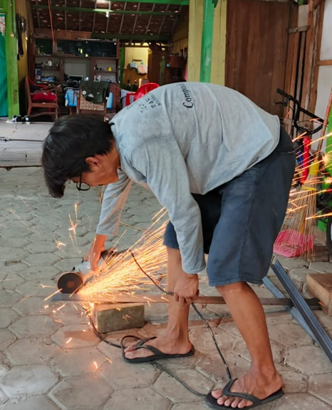 Mahasiswa KKN 13 UNS saat melakukan proses pembuatan prototype mesin pengering jagung. (doc. KKN 13 UNS)