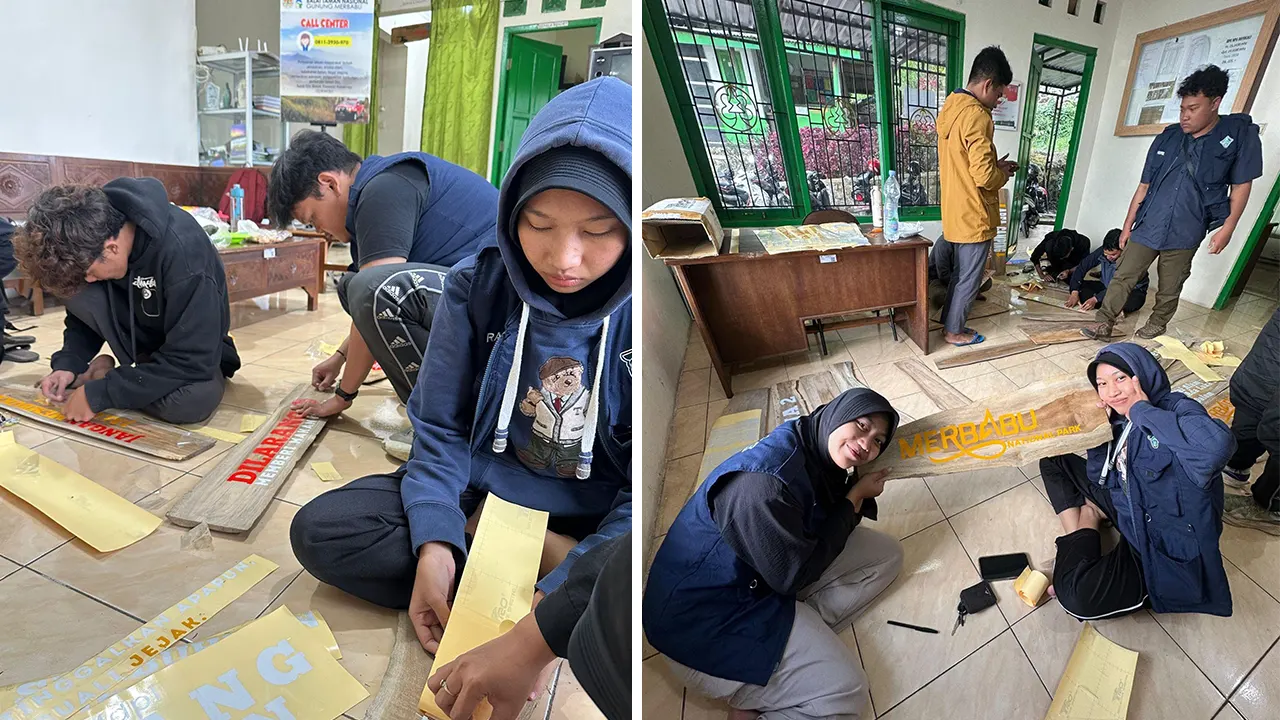 Mahasiswa KKN 32 UNS membantu memasang stiker informasi papan jalur pendakian Gunung Merbabu sebelum dipasang. (doc. KKN 32 UNS)