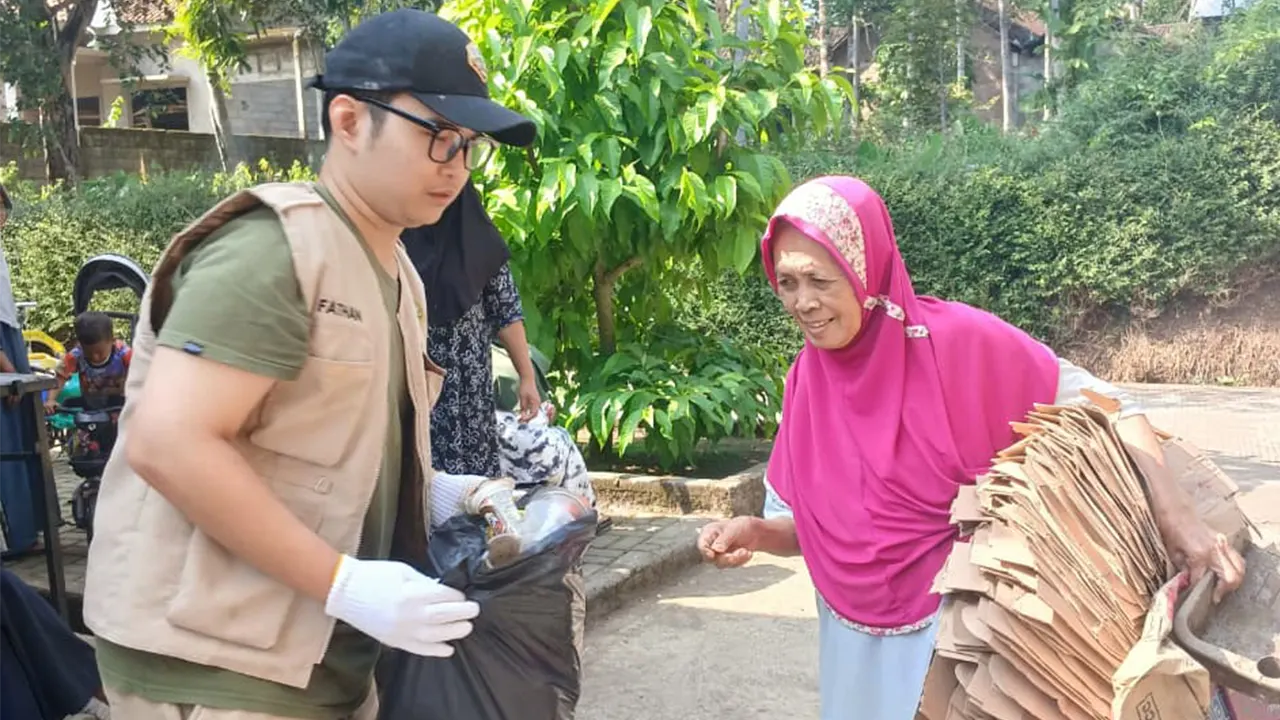 Mahasiswa KKN UNS 273 membantu warga dalam pengumpulan sampah anorganik dan kardus bekas sebagai bagian dari program peduli lingkungan. (doc. KKN 273 UNS)