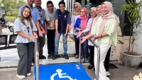 Mahasiswa KKN UNS bersama perangkat desa dan perwakilan NPC Indonesia berfoto di depan jalur landai ramah disabilitas yang baru dibangun di Kantor Desa Ponggok, Klaten. (doc. KKN 103 UNS)