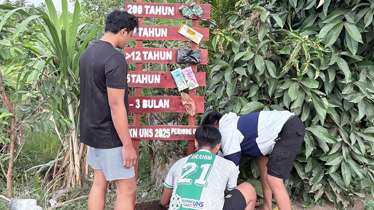 Mahasiswa KKN UNS saat memasang plang edukasi waktu penguraian sampah di Dusun Gumesa Tengah, Desa Giri Tembesi, Lombok Barat. (doc. KKN 136 UNS)