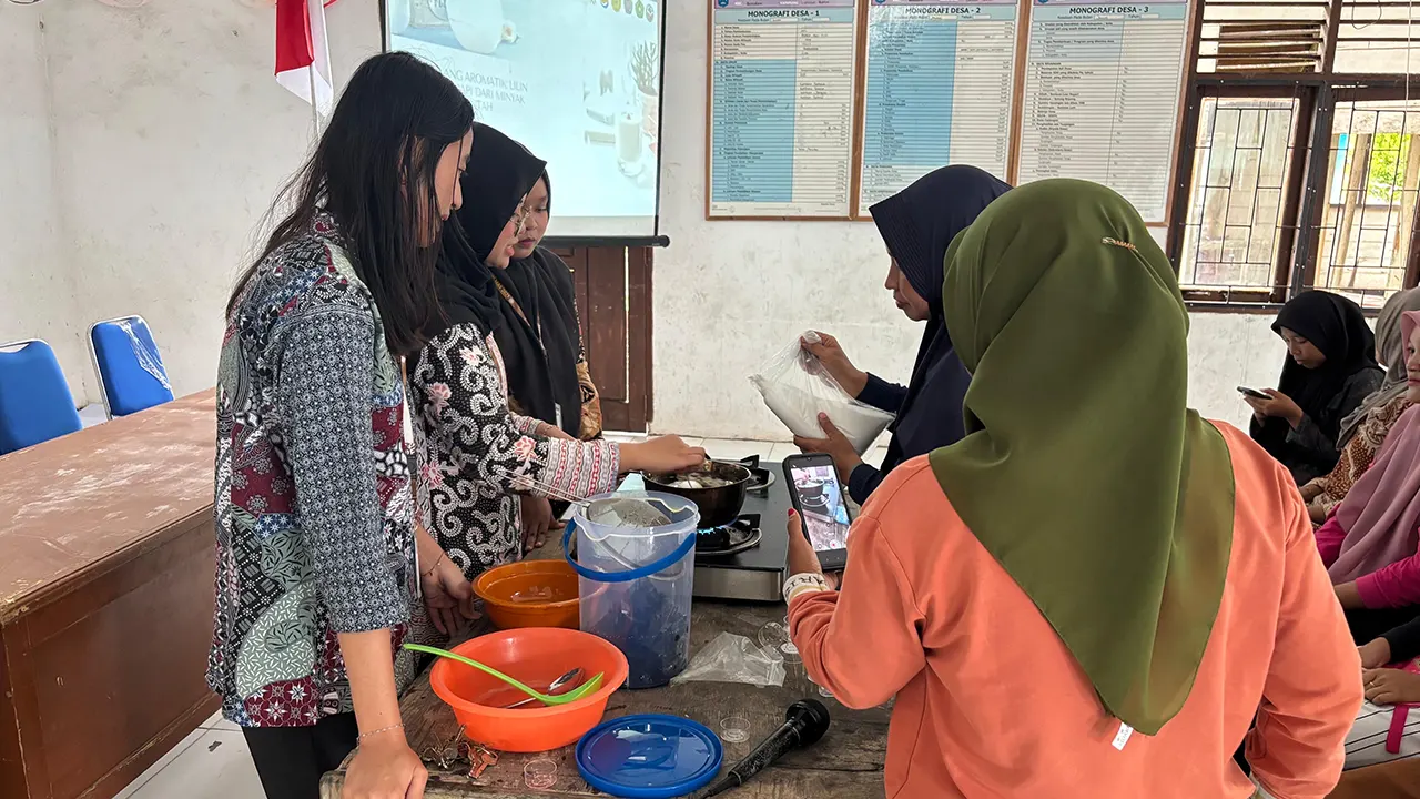 Mahasiswi KKN MAS Kelompok 33 Desa Langsat Permai membimbing warga dalam praktik pembuatan lilin aromaterapi dari minyak jelantah pada workshop di Balai Desa, Senin (1/9/2025). (doc. KKN MAS Kelompok 33) Mahasiswi KKN MAS Kelompok 33 Desa Langsat Permai membimbing warga dalam praktik pembuatan lilin aromaterapi dari minyak jelantah pada workshop di Balai Desa, Senin (1/9/2025). (doc. KKN MAS Kelompok 33)