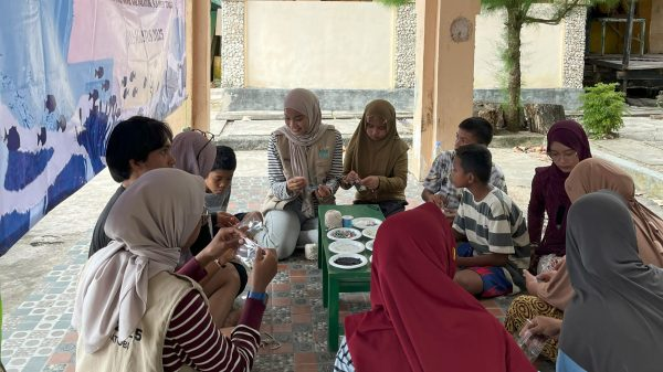 Mahasiswa KKN 338 UNS membimbing anak-anak pesisir Wakatobi membuat kerajinan tangan dari limbah cangkang kerang dalam program Gema Kreasi. (doc. KKN 338 UNS)
