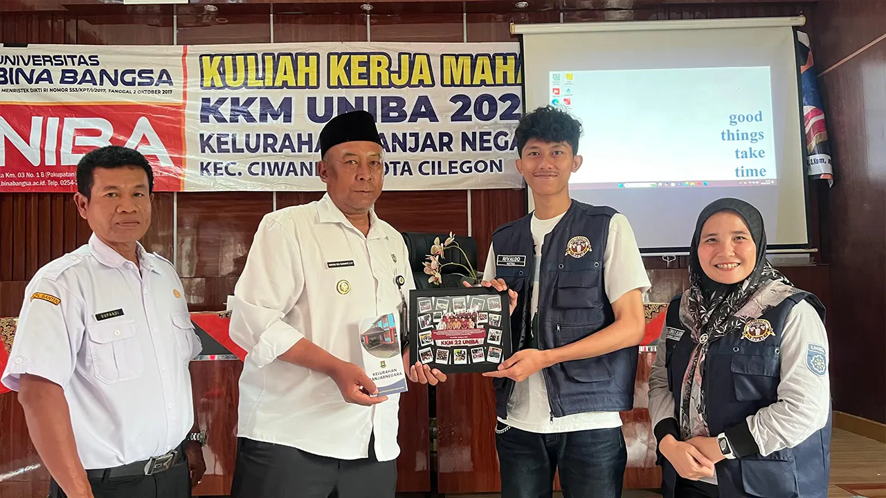 Perwakilan mahasiswa KKM 22 UNIBA menyerahkan brosur profil Kelurahan Banjarnegara kepada Lurah Banjarnegara, Kecamatan Ciwandan, Kota Cilegon, dalam acara penutupan kegiatan KKM, Sabtu (6/9/2025). (doc. KKM 22 UNIBA )