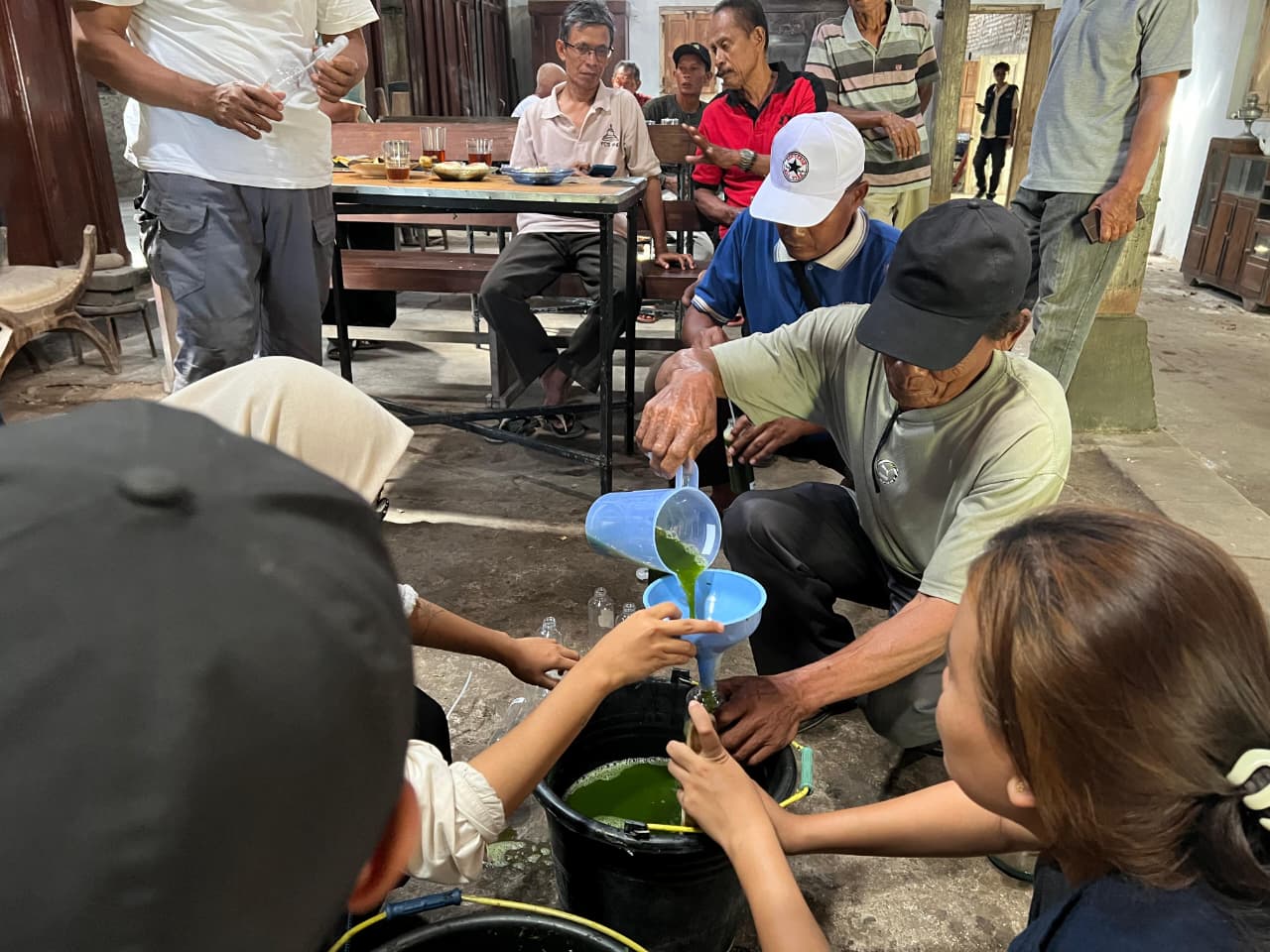 Petani bersama mahasiswa KKN UNS Kelompok 113 mempraktikkan proses penyaringan dan pengemasan pestisida nabati berbahan dasar daun pepaya dalam pelatihan di Desa Kebondalem Kidul. (doc. KKN 113 UNS)
