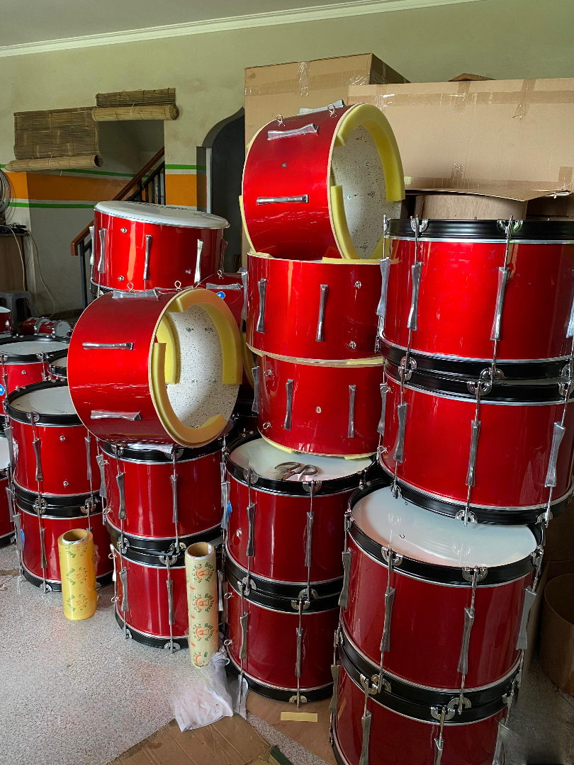 Tumpukan bass drum merah siap dikirim ke berbagai sekolah dan komunitas marching band. Peralatan baru ini jadi penunjang utama performa tim perkusi. (doc. pabrikalatdrumband.com)