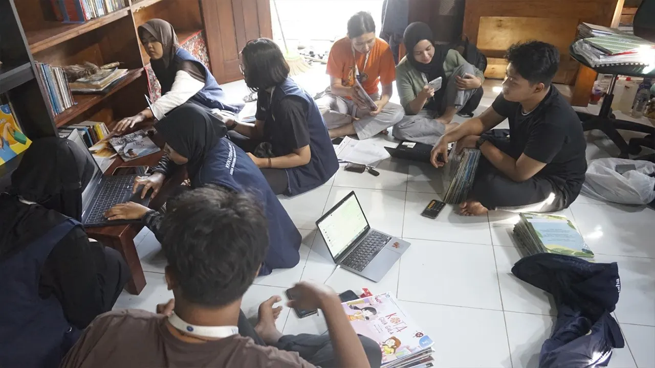 Mahasiswa KKN 164 UNS saat memeriksa kondisi buku bantuan Perpusnas yang dilarang untuk dibuka dan dibaca, sebuah kebijakan yang menghentikan layanan perpustakaan di desa. (doc. KKN Literasi 164 UNS)