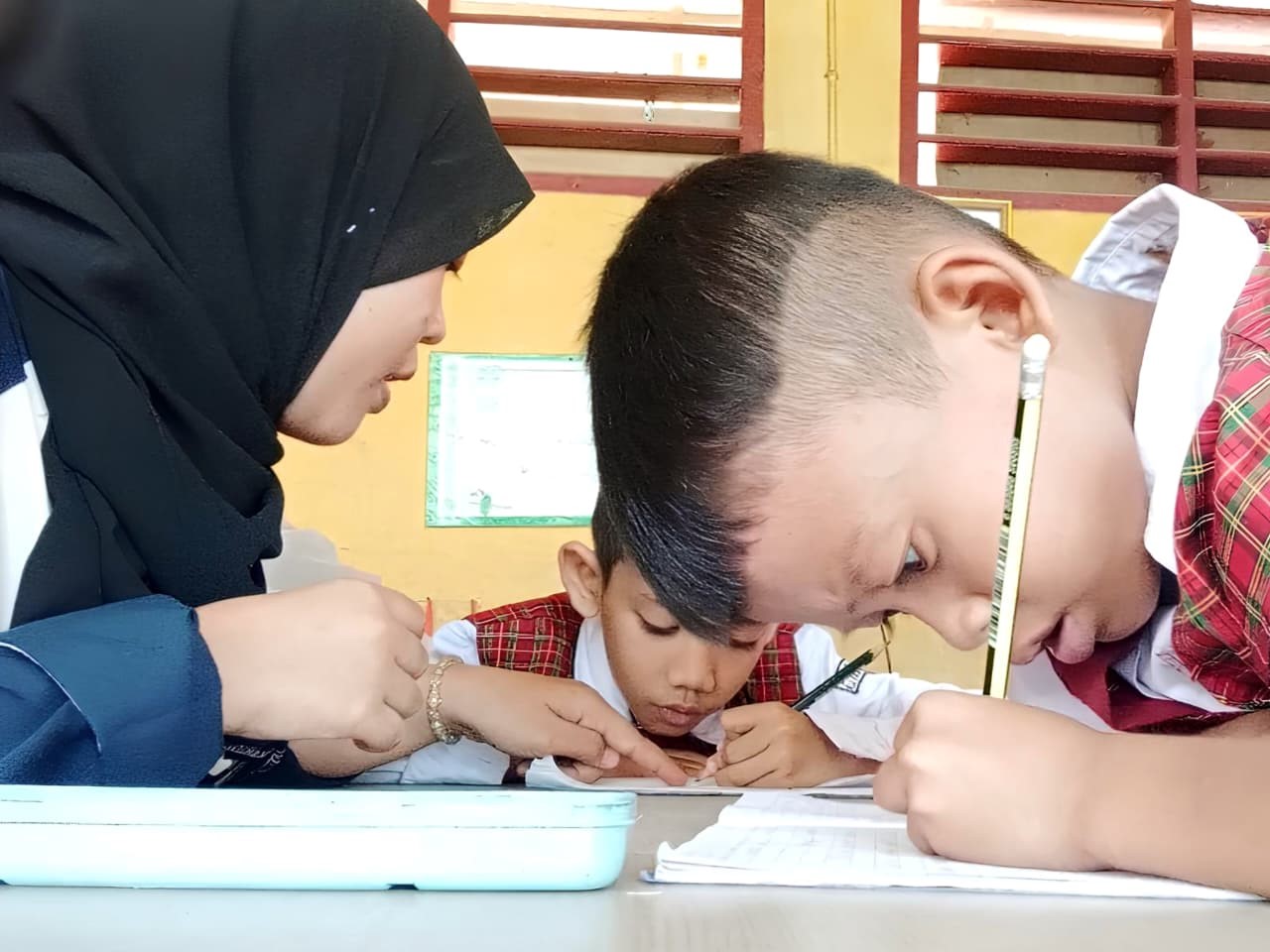 Ilustrasi seorang guru dengan sabar membimbing siswa sekolah dasar dalam proses belajar menulis di kelas. (doc. pribadi)