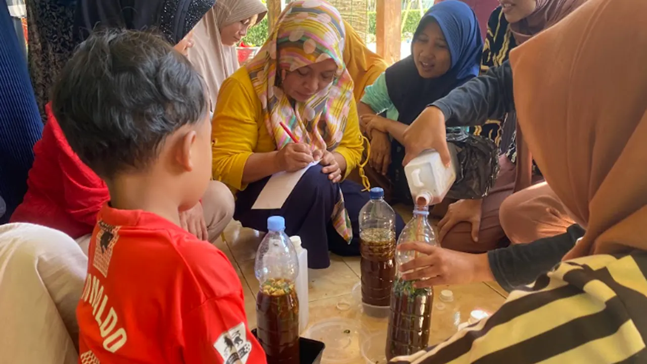 Ibu-ibu Desa Doplang mengikuti pelatihan pembuatan ekoenzim yang digelar tim pengabdian UNS. Mereka mempraktikkan proses pencampuran bahan limbah dapur menjadi larutan ramah lingkungan. (doc. pribadi)