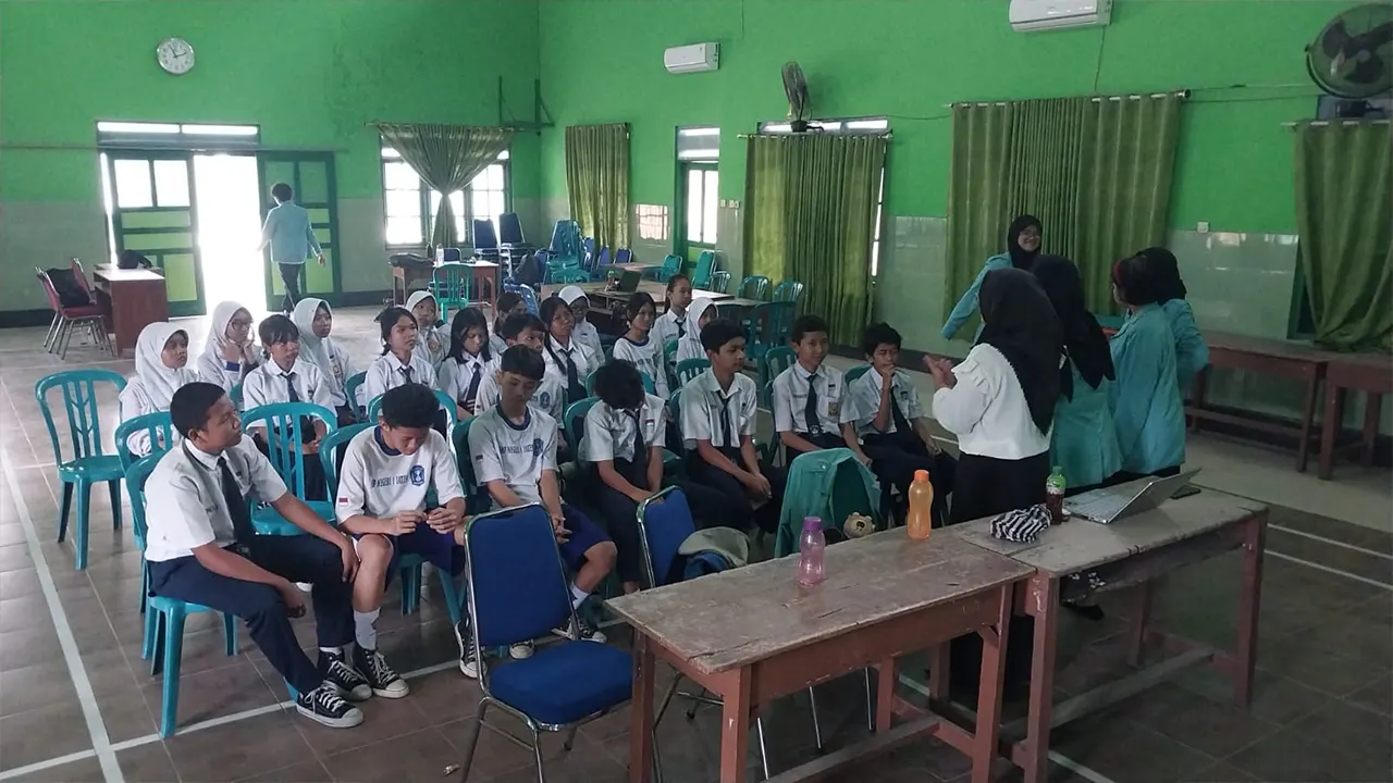 Mahasiswa Program Kampus Mengajar UNS memberikan pendampingan bahasa Inggris kepada siswa SMP Negeri 1 Jaten di aula sekolah. (doc. pribadi)