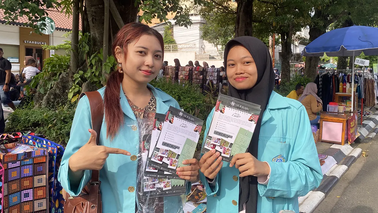 Mahasiswi Sejukain membagikan brosur dan memperkenalkan produk wastra kepada pengunjung CFD Slamet Riyadi, Surakarta, dalam rangkaian Workshop “Mix & Match Wastra ala Sejukain.” (doc. pribadi)