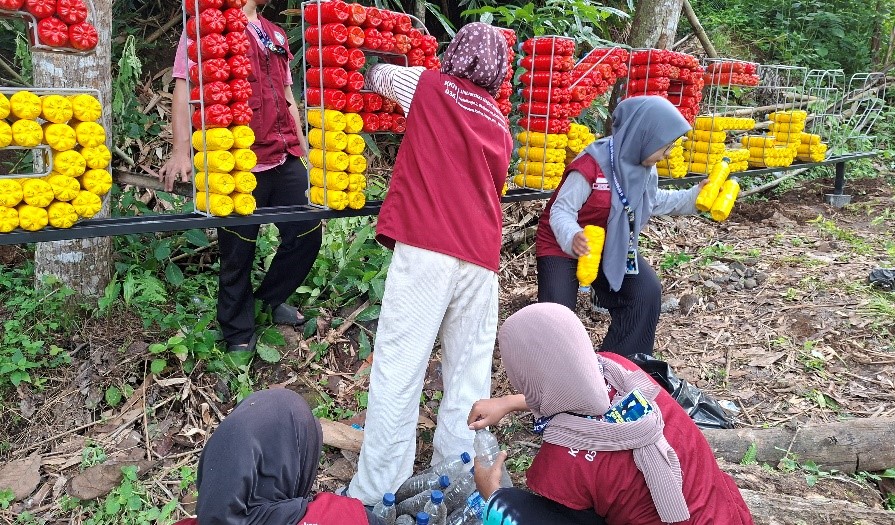 Proses pemasangan botol ecobrick ke dalam kerangka oleh mahasiswa KKN. (doc. pribadi)