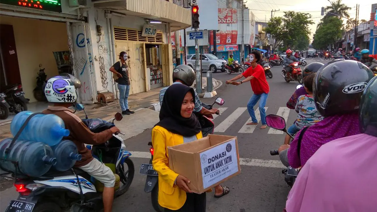 Foto Ilustrasi: Seorang mahasiswi menggalang donasi untuk anak yatim di tengah kepadatan lalu lintas kota, menunjukkan kepedulian generasi muda yang turun langsung ke ruang publik untuk aksi sosial. (Foto: Dok Humas Pemkot Tegal)