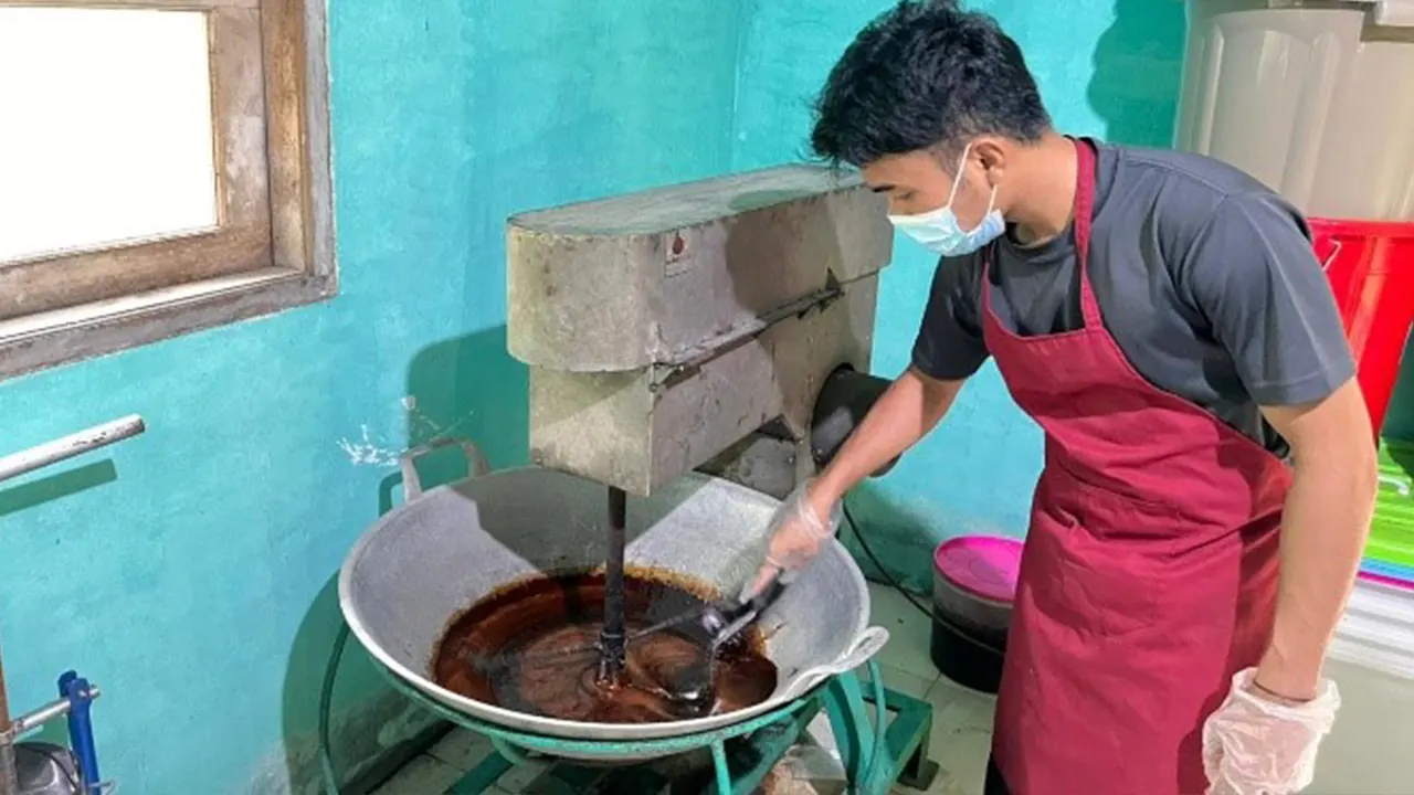 Uji teknis mengaduk larutan nira aren saat proses pembuatan gula semut menggunakan peralatan produksi di Desa Giri Madia, Lombok Barat. (doc. Tim KKN Tematik Desa Giri Madia)