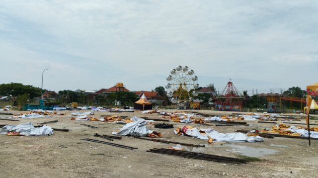 Kondisi Lapangan Gajah Mada, Lamongan, Minggu (20/12/2025), dipenuhi rangka besi dan terpal stan pasar malam yang roboh usai diterjang hujan deras disertai angin kencang. (doc. (pribadi)