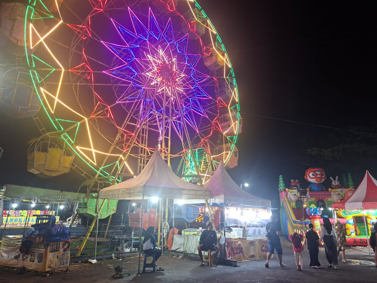 Wahana bianglala dan aneka permainan anak memeriahkan pasar malam di Pelabuhan Timur, Kecamatan Kamal, Bangkalan. (doc. pribadi)