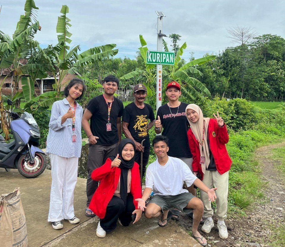 Dokumentasi kegiatan Pengabdian kepada Masyarakat R14 Mahasiswa Universitas 17 Agustus 1945 Surabaya Subkelompok 1 bersama Kepala Dusun Kuripan dalam pemasangan plang informasi berlampu panel surya di Dusun Kuripan, Desa Kuripansari, Kecamatan Pacet, Mojokerto. (doc. pribadi)