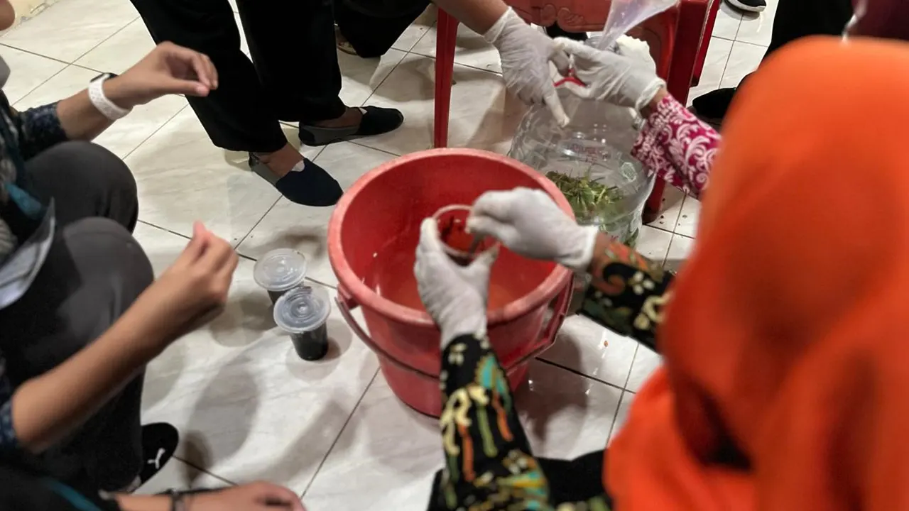 Anggota Kelompok Wanita Tani (KWT) Desa Semagung praktik membuat pupuk organik cair (POC) menggunakan EM4 dan molase. (doc. Tim KKN 114 Desa Semagung, Bagelen, Purworejo)