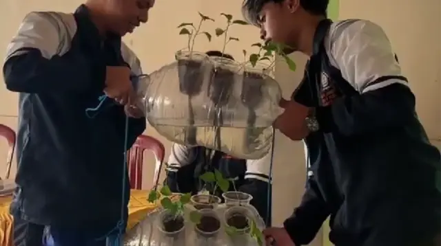 Mahasiswa KKN Tim 1 UNDIP memperagakan proses perakitan aquaponic vertikal garden dari galon bekas sebagai media tanam alternatif dalam kegiatan sosialisasi pemanfaatan lahan terbatas di Desa Pagak, Kabupaten Sragen. (doc. pribadi)