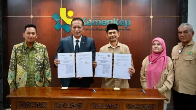 Menteri Koperasi dan UKM Ferry Juliantono (tengah) bersama Ketua Umum Serikat Petani Indonesia (SPI) Henry Saragih (kedua kanan) menunjukkan dokumen Nota Kesepahaman (MoU) usai penandatanganan kerja sama di Kantor Kementerian Koperasi dan UKM, Jakarta, Kamis (5/2/2026). (doc. Humas Kementerian Koperasi)