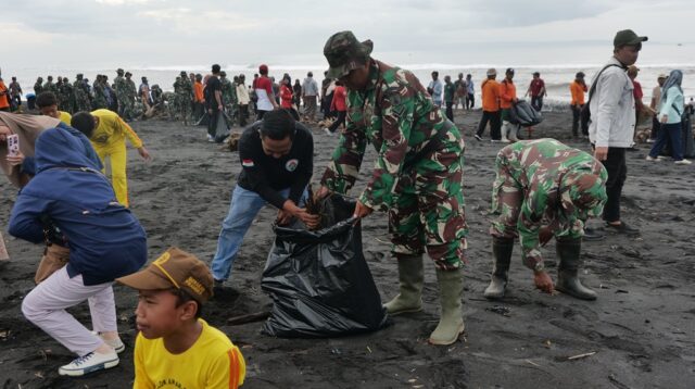 Personel TNI, aparat terkait, dan masyarakat bergotong royong membersihkan sampah saat kegiatan Karya Bhakti Terpadu Pembersihan Sampah Laut di Pantai Watuk Pecak, Kecamatan Pasirian, Kabupaten Lumajang, Jumat (6/2/2026). Aksi ini mencerminkan kolaborasi lintas sektor dalam menjaga kebersihan pesisir sebagai upaya mendukung lingkungan sehat dan pembangunan pariwisata berkelanjutan. (doc. Kominfo Lumajang/Anbiya)