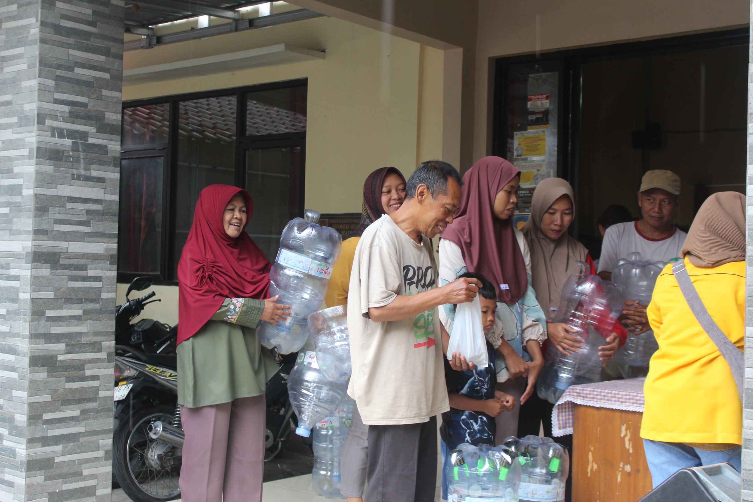 Warga Dusun Kembangan 2, Desa Madusari, Kabupaten Magelang, membawa galon bekas yang akan dimanfaatkan sebagai media budidaya ikan lele dan sistem akuaponik dalam kegiatan sosialisasi yang digelar mahasiswa KKN Universitas Tidar, Minggu (1/2/2026). (doc. pribadi)