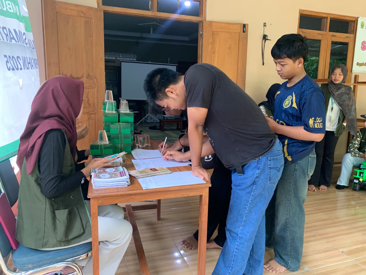 Peserta kegiatan melakukan registrasi sebelum mengikuti sosialisasi mitigasi bencana berbasis pemetaan tematik yang diselenggarakan mahasiswa KKN UNS Kelompok 09 di Padukuhan Umbulsari, Bantul, Minggu (15/2/2026). (doc. pribadi)
