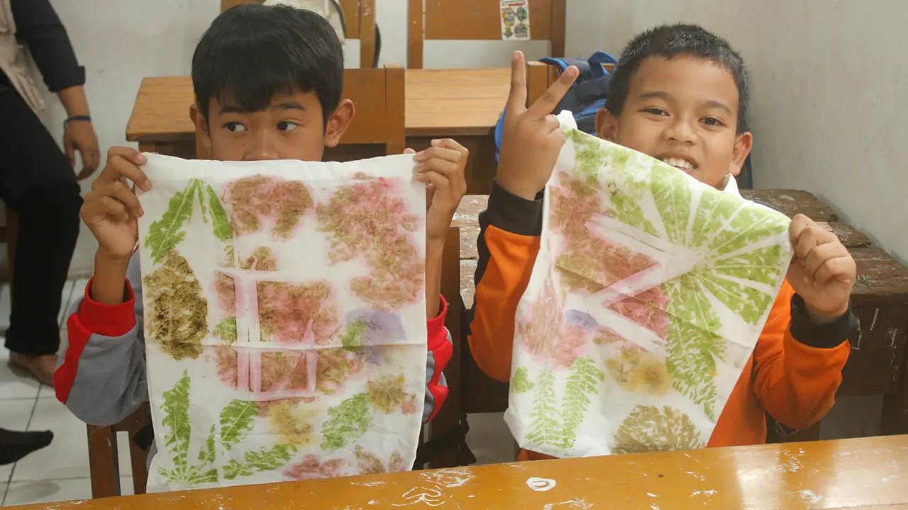 Bangga: 2 siswa menunjukan hasil ecoprint yang telah berhasil mereka buat. (doc. pribadi)
