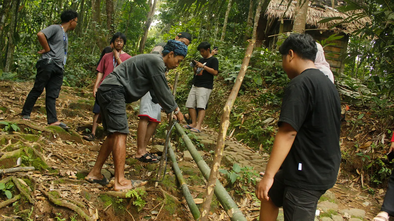 Mahasiswa KKN bersama warga masyarakat Baduy bergotong royong memasang pegangan tangga dari bambu di jalur akses Desa Kanekes, Kabupaten Lebak, Banten. (doc. pribadi)