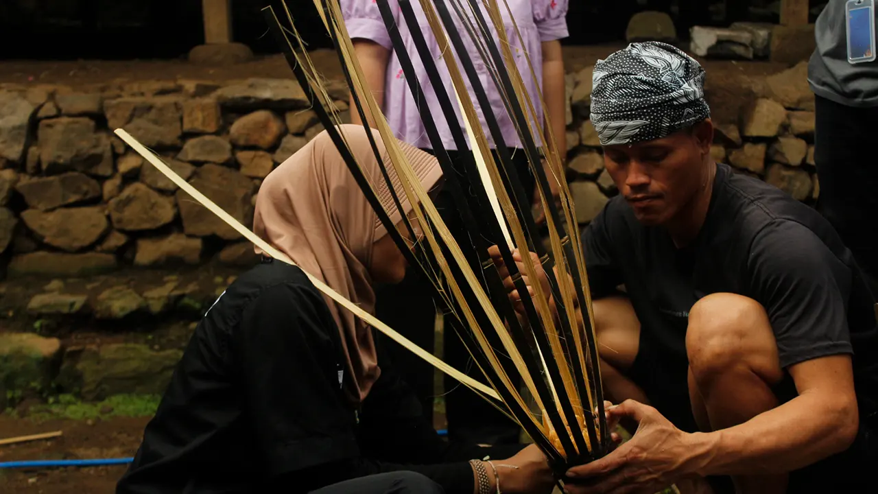 Mahasiswa KKN dan masyarakat Adat Baduy memproduksi wadah pemilahan sampah dengan teknik anyaman bambu tradisional. (doc. pribadi)