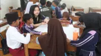 Mahasiswa KKN saat menjelaskan cara pembuatan shibori bagi siswa di SDN 1 Bojong Menteng, Desa Bojong Menteng, Kecamatan Leuwidamar. (doc. pribadi)