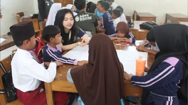 Mahasiswa KKN saat menjelaskan cara pembuatan shibori bagi siswa di SDN 1 Bojong Menteng, Desa Bojong Menteng, Kecamatan Leuwidamar. (doc. pribadi)