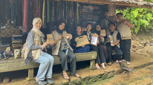 Mahasiswa berfoto bersama sambil menunjukan hasil branding UMKM Pulung Tenun Baduy. (doc. pribadi)