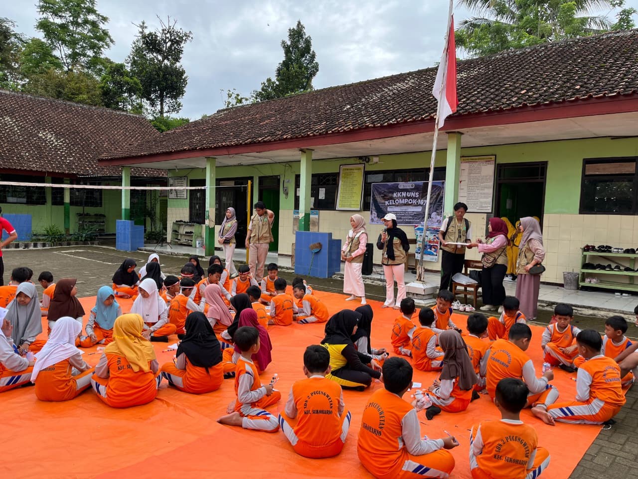 Mahasiswa KKN UNS Kelompok 167 memberikan arahan kepada siswa SD Negeri 2 Pucungwetan sebelum praktik melukis pot dan menanam hidroponik sederhana dalam kegiatan Green Fun Day, Selasa (22/1/2026). (doc. pribadi)