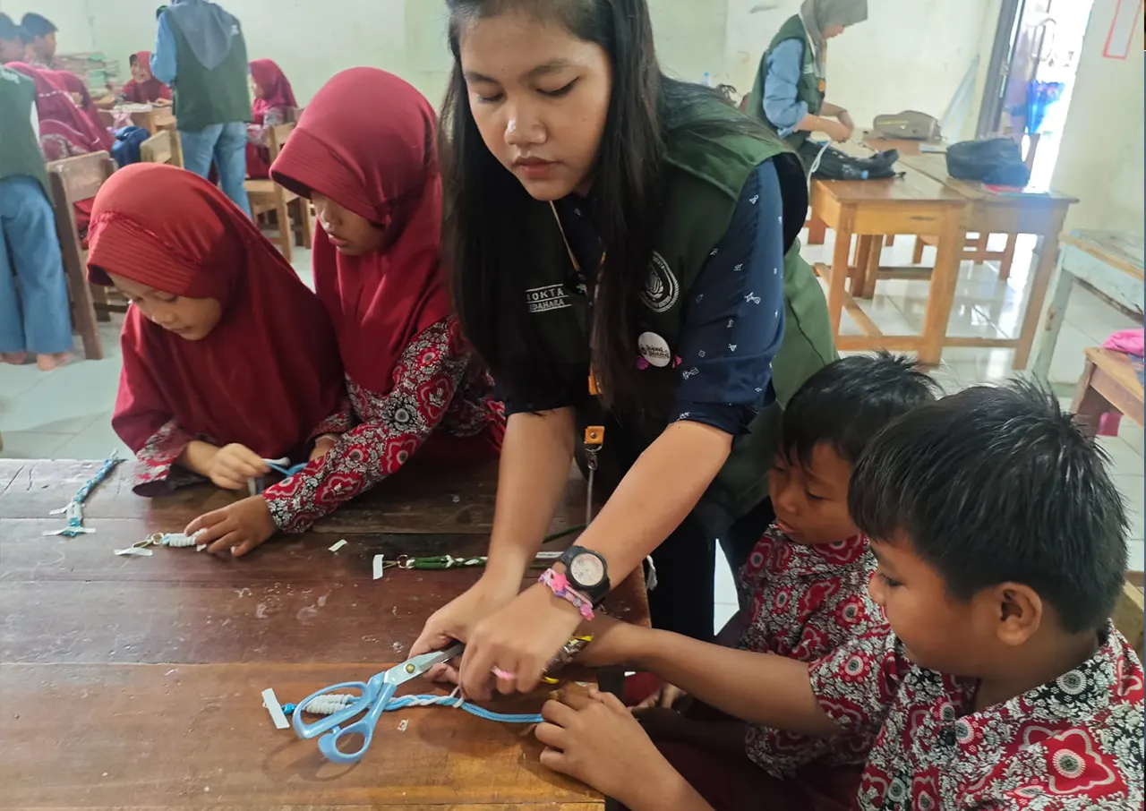 Mahasiswa KKN saat mendampingi pelatihan pembuatan gantungan tas dari benang makrame bagi siswa di SDN 1 Bojong Menteng, Kecamatan Leuwidamar. (doc. pribadi)
