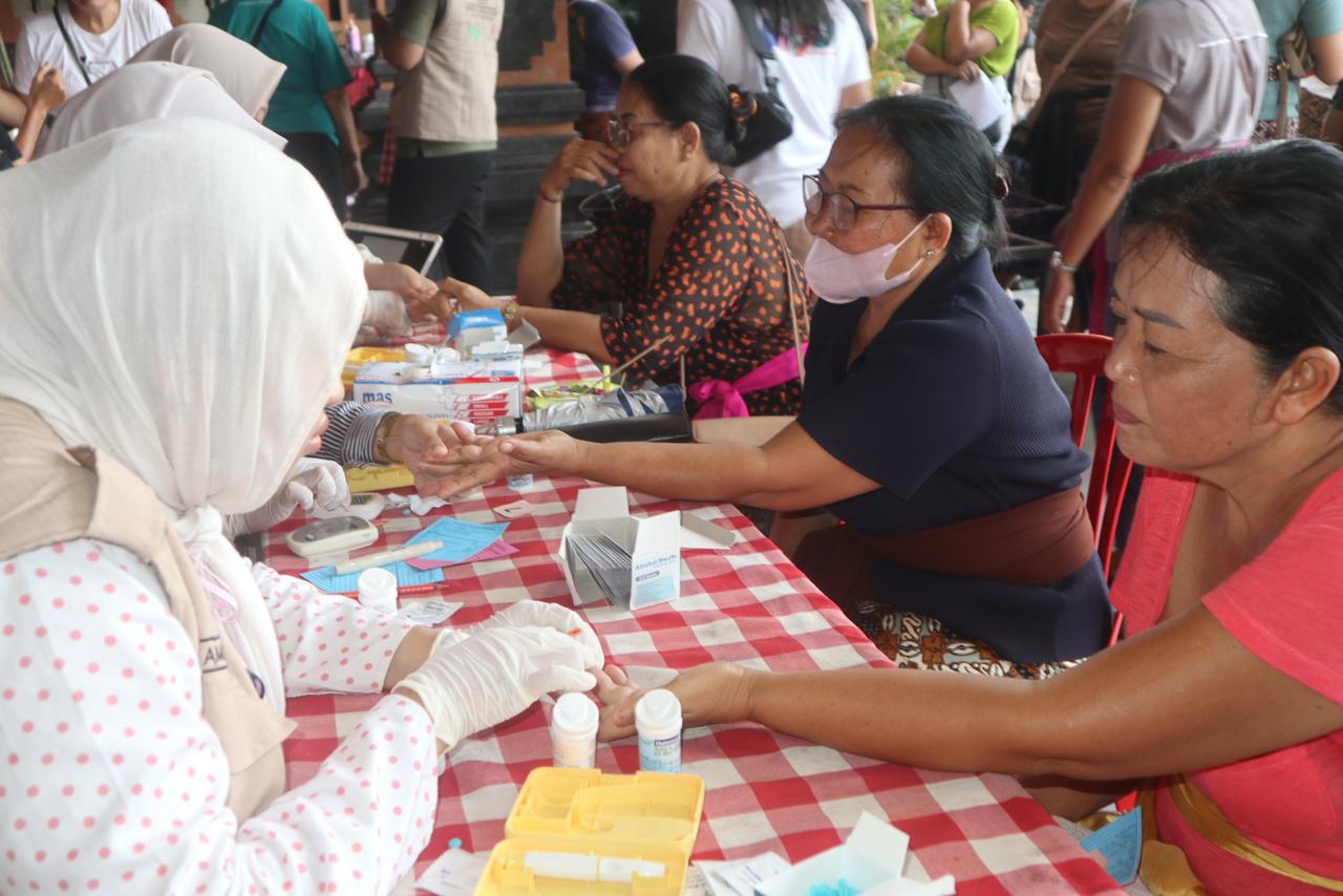 Mahasiswa KKN UNS Kelompok 183 Batubulan bersama tenaga kesehatan melakukan pemeriksaan gula darah dan kesehatan dasar kepada warga dalam kegiatan Batubulan Health Fair di Desa Batubulan, Kecamatan Sukawati, Kabupaten Gianyar, Bali. (doc. pribadi)