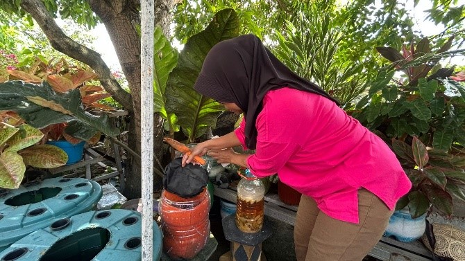 Seorang warga RW 7 Wonokromo menunjukkan proses pengolahan sampah organik rumah tangga menggunakan metode galon kura di lingkungan permukiman Surabaya, beberapa waktu lalu.(doc. pribadi)