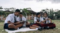 Ilustrasi siswa membaca buku di luar kelas. Foto oleh Roman Odintsov via Pexels