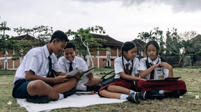 Ilustrasi siswa membaca buku di luar kelas. Foto oleh Roman Odintsov via Pexels
