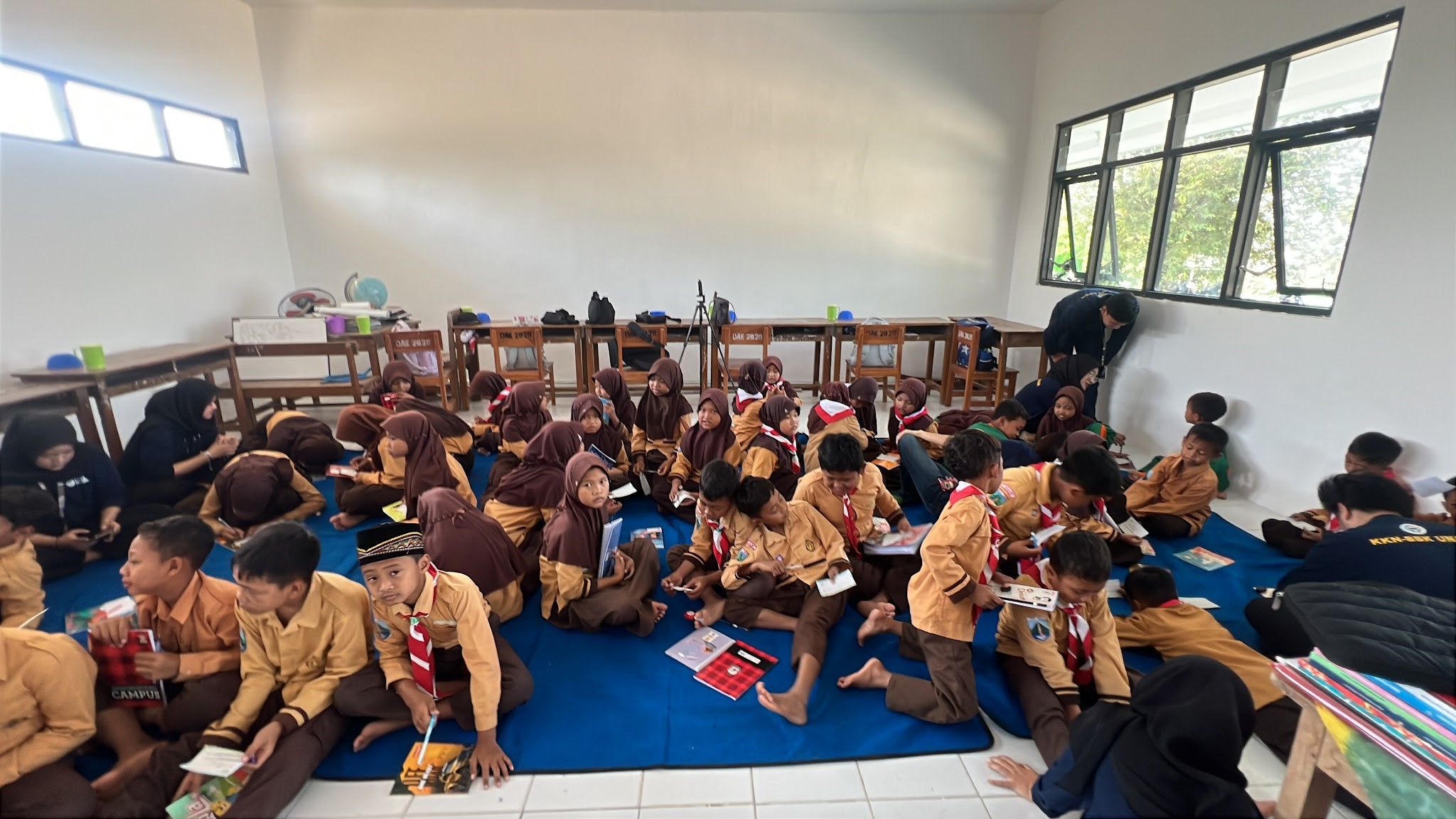 Mahasiswa UNAIR mendampingi siswa-siswi SDN 3 Gunungsari dalam sesi penulisan cita-cita di lembar harapan pada Jumat (31/7/2026), sebagai upaya menanamkan motivasi dan keberanian anak-anak untuk bermimpi tinggi. (Dok. Pribadi)