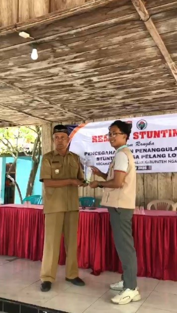 Penyerahan plakat oleh ketua Kelompok KKN 29 kepada Kepala Desa sekaligus penutupan program KKN di Balai Desa Pelang Lor. (Dok. KKN 29 UINSA)