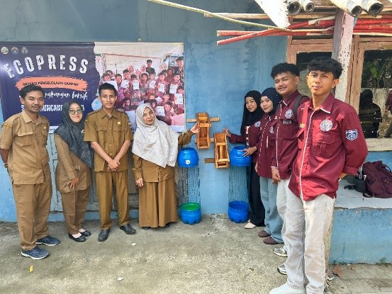 Mahasiswa KKM 82 UNIBA bersama guru SDN 02 Muncangkopong berfoto di samping alat Eco-Press yang diserahkan untuk mendukung edukasi pengelolaan sampah di lingkungan sekolah. (Doc. Pribadi)