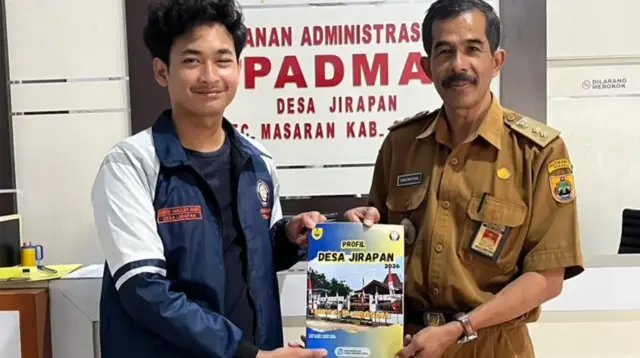 Mahasiswa UNDIP Dzikri Maulidi Amin saat menyerahkan Buku Profil Desa Jirapan 2026 kepada pihak Desa Jirapan. (Dok. Pribadi)