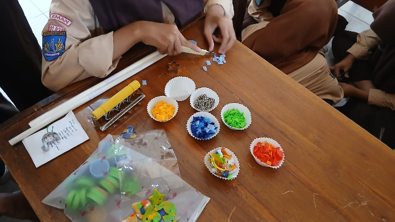 Proses pemotongan tutup botol plastik sebelum disetrika. (Dok. Pribadi)