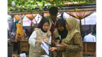 Mahasiswa KKN UNS Kelompok 49 melakukan pendampingan langsung kepada pelaku usaha dalam proses pengenalan dan pendaftaran pembayaran non-tunai. (Dok. Pribadi/KKN 49 UNS)