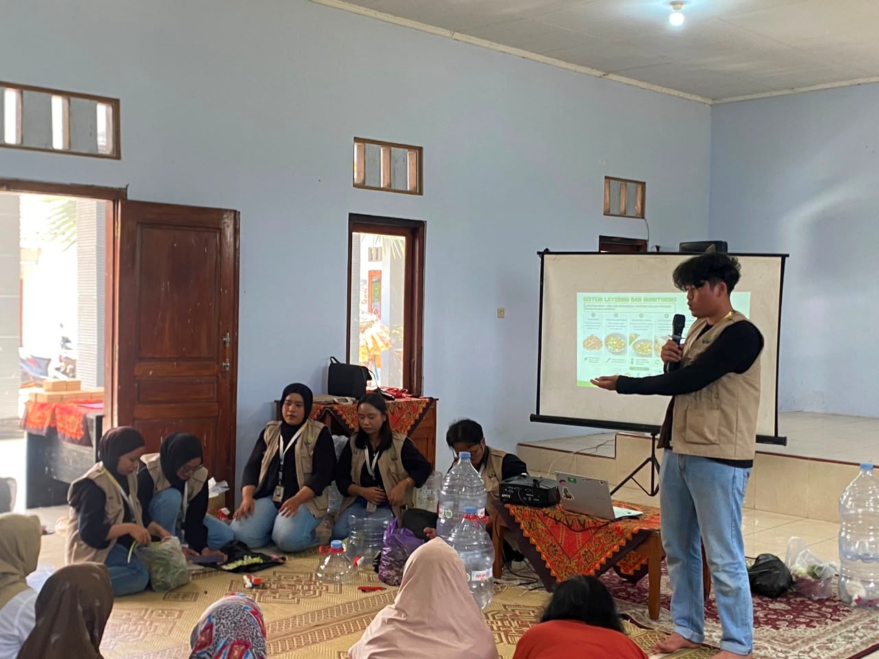Mahasiswa KKN 227 UNS mendemonstrasikan pembuatan komposter galon kepada masyarakat Desa Payungan. (Dok. KKN 227 UNS)