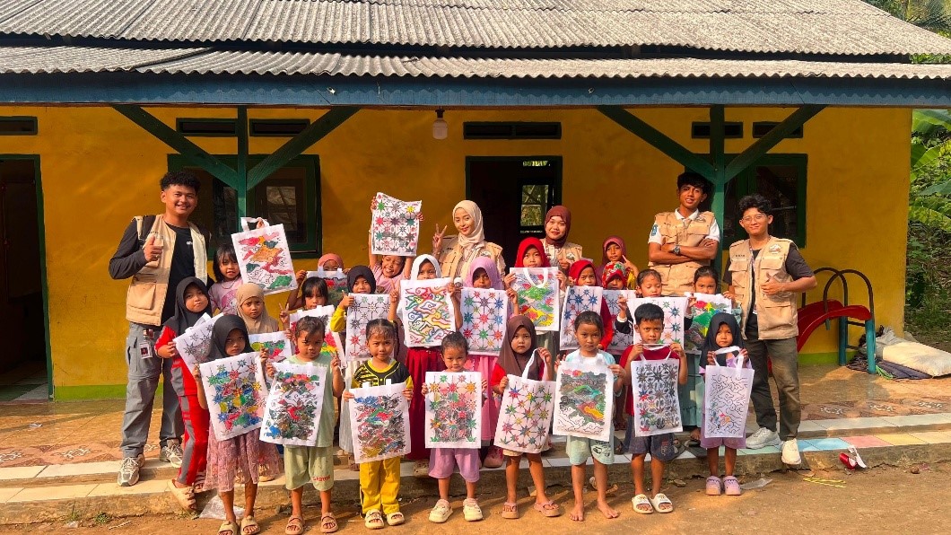 Dokumentasi bersama setelah kegiatan mengenalkan batik kepada siswa Madrasah Diniyah Insanul Kamil, Desa Muncangkopong, Kecamatan Cikulur, melalui kegiatan mewarnai motif batik pada totebag. (Dok. Pribadi/KKM 82 UNIBA)
