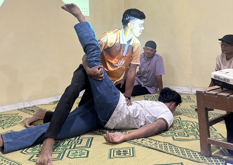 Praktik Teknik Penanganan Cedera oleh Narasumber dan Ketua Tim KKN UNS Kelompok 298. (Dok. Pribadi/KKN 298 UNS)