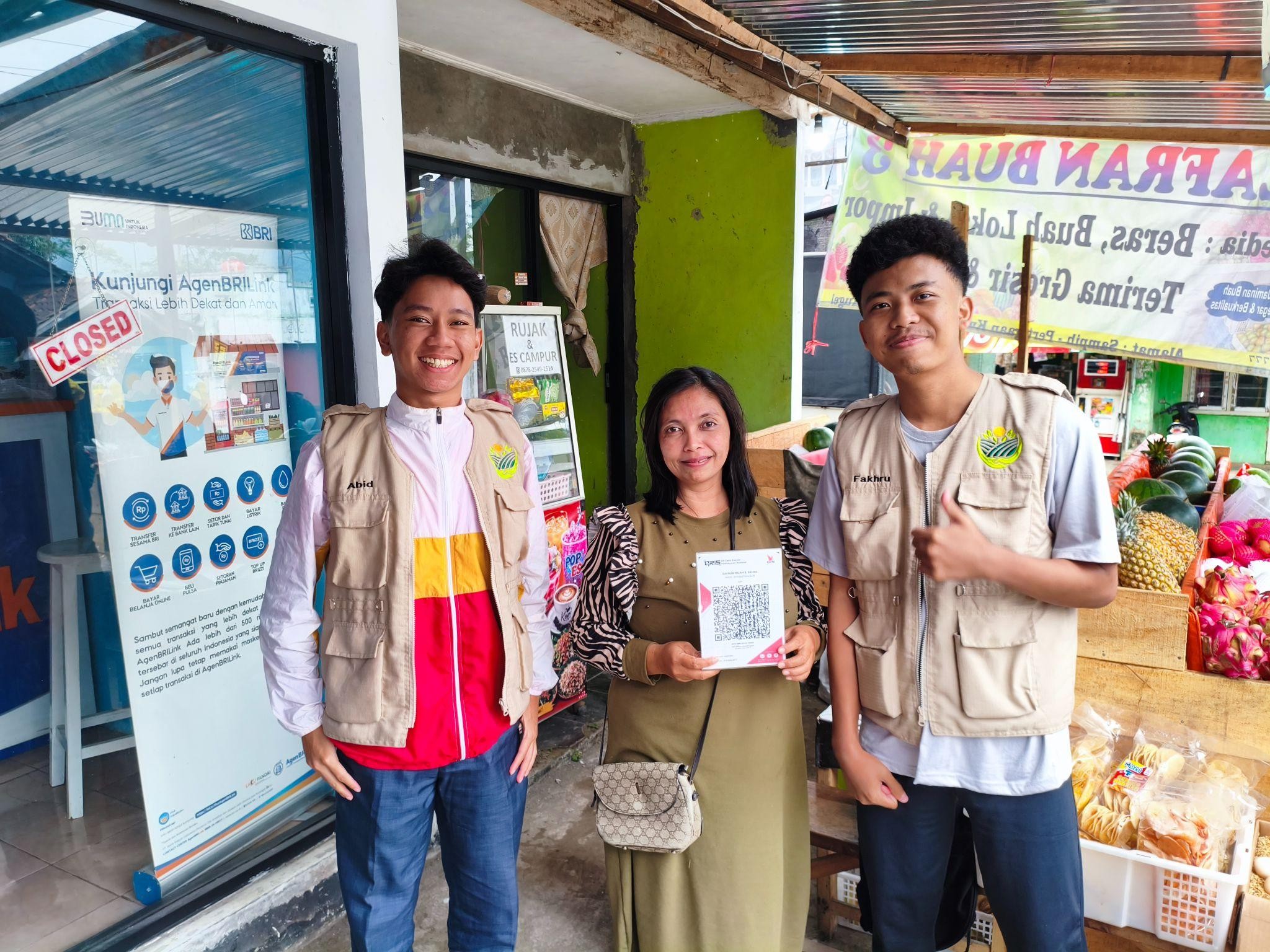 Mahasiswa KKN 277 UNS memberikan pendampingan pembuatan pembayaran digital QRIS kepada UMKM di Desa Sukoharjo pada (14/8/2026). (Dok. Pribadi/KKN 277 UNS)