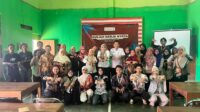Tim KKN UNS Kelompok 268 bersama pelaku UMKM, Pemerintah Kelurahan Mlokomanis Kulon, dan Dinas Perdagangan dan KUKM Kabupaten Wonogiri berfoto bersama seusai kegiatan sosialisasi digitalisasi UMKM di Aula Kelurahan Mlokomanis Kulon, Wonogiri, Juli 2026. (Dok. Pribadi/KKN 268 UNS)